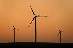 Electricity Generation From Wind Drucke: Three wind wheels in the sunset sky