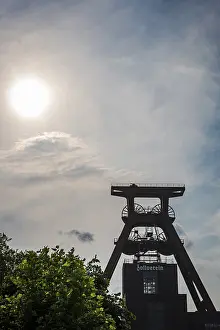 Drucke von Ein Industriedenkmal im Sonnenlicht: Der Winding Tower der Zeche Zollverein in Essen, Deutschland Essen Drucke: Zeche Zollverein, Wasserturm bei Sonnenuntergang