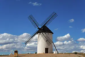 Don Quixote Route Photography Drucke: A windmill under a clear, cloudy sky