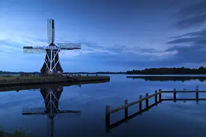 Dutch Windmill Landscape Drucke: Windmill close to lake at sunset