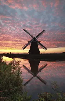 Dutch Countryside Landscape Drucke: Windmill and dramatic sunrise sky reflected in river