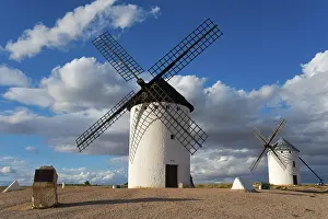 Castile La Mancha Landscapes Drucke: Windmill in a rural setting under a blue sky with dramatic clouds