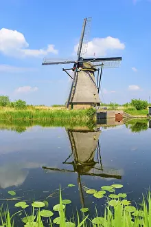 Drucke von Die Windmühlen und die Wasserreflexion in Kinderdijk, ein UNESCO-Weltnaturerbe in Rotterdam, Niederlande Rotterdam Drucke: Die Windmühlen und die Spiegelung auf dem Wasser in Kinderdijk.