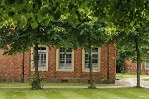 Northern German Architecture Drucke: Window of a brick building, framed by green trees