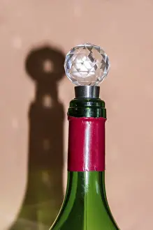 Alcoholic Beverage Images Drucke: A wine bottle with cap casts shadows on the wall