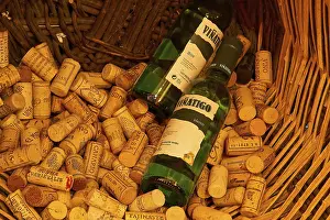 Wine Museum Tenerife Drucke: Wine bottles and numerous corks in a large basket in a rustic setting