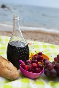 Wine And Fruit Still Life Drucke: Wine bread and fruit at the picnic on the beach