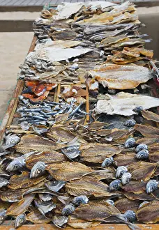 Dried Fish On Beach Drucke: A wire rack with different types of dried fish on the beach