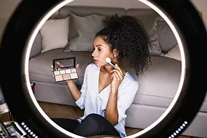 Cosmetic Product Photography Drucke: Woman beauty vlogger recording a makeup tutorial on camera using ring light