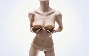 Plastic Surgery Concept Drucke: Woman posing in the studio with coconuts in her hands