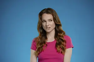 Eine Frau posiert in einem Studio und zeigt eine einzigartige Miene.