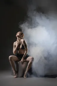 Dark Art Photography Drucke: A woman strikes a dramatic pose on a stool