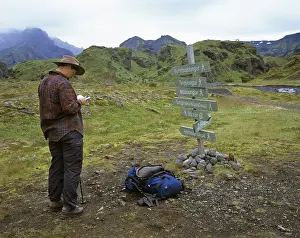 Female Hiker Drucke: Woman studies map in front of a guidepost