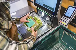 Cashless Payment Systems Drucke: Woman using a self checkout machine
