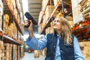 Distribution Warehouse Worker Drucke: Woman worker scanning package with bar code reader in a distribution warehouse