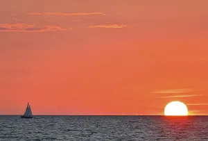 Segelboot segelt am Abend gegen den untergehenden Sonnenuntergang