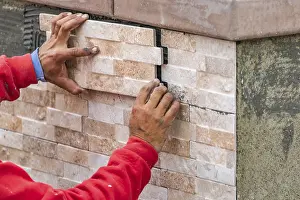 Construction Industry Workforce Drucke: Worker installing wall tile at construction site