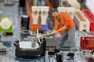 Data Security Concept Drucke: A worker repairs the circuit board of a computer