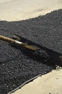 Road Construction Drucke: A worker is smoothing fresh tar