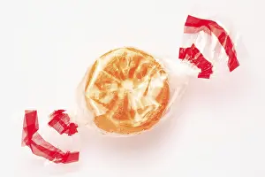 White Background Confectionery Drucke: Wrapped fruit candy in the shape of an orange slice