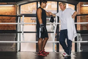 Young Boxer Drucke: Young boxer talking with his mature instructor in ring