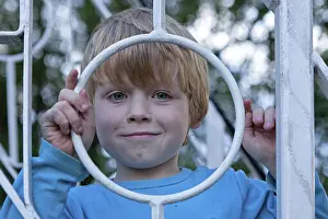 North German Landscape Photography Drucke: Young boy looking through a fence