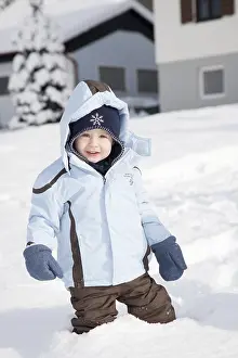 Happy Caucasian Child Drucke: Young boy standing in the deep snow