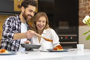 Young Couple Breakfast Drucke: Young couple having breakfast in kitchenn