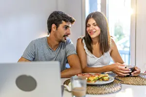 Kitchen Conversation Drucke: Young couple talking and having breakfast in their kitchen