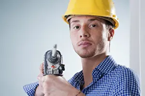 Young Craftsman Drucke: Young craftsman using a drill