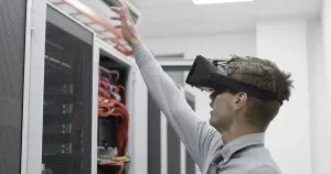 Server Room Background Drucke: Young IT engeneer using virtual reality headset over server room background