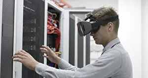 Server Room Background Drucke: Young IT engeneer using virtual reality headset over server room background