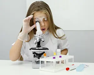 Scientist In Lab Coat Drucke: Young girl scientist using microscope