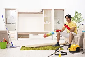 Man Doing Household Chores Drucke: Young handsome man doing housework