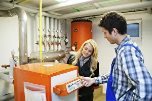 Energy Consumption Reduction Drucke: Young heating technician maintains a heating system