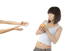 Studio Food Photography Drucke: Young lady with apple and two hands asking to help