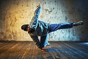 Young Man Break Dancing Drucke: Young man break dancing on wall background