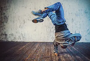 Gerahmter Druck : Jüngerer Mann breakdances auf einer Wand im Hintergrund.