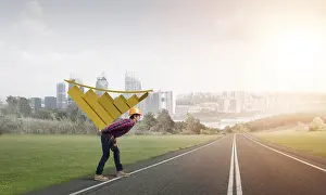 Young Construction Worker Drucke: Young man builder carrying growing graph on his back