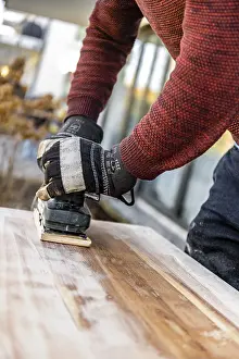 Young Man DIY Drucke: Young man doing DIY, grinding table with a grinder