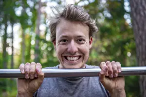 Athletic Male Portrait Drucke: Young man doing pull-ups on a pull-up bar