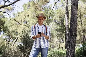 Smartphone User Drucke: A young man, dressed casually with a hat