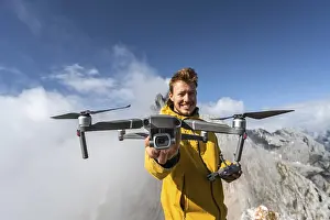 Remote Controlled Aircrafts Drucke: Young man holding a drone with camera