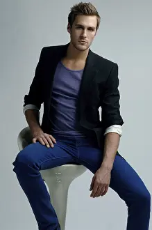 Casual Clothing Model Drucke: Young man in a jacket sitting on a stool