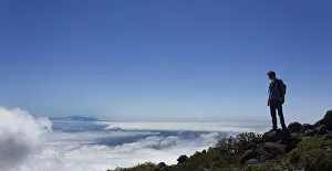 Panoramic Mountain View Drucke: Young man looking across a layer of clouds
