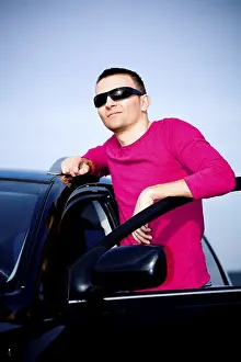 Young Man In Car Drucke: Young man standing at a car