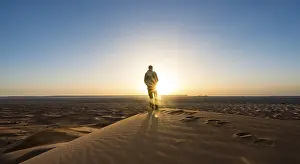 Erg Chebbi Dunes Morocco Drucke: Young man standing on sand dune