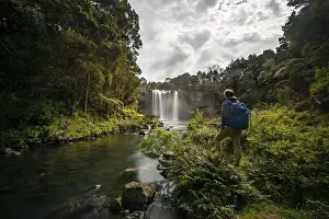 Young Man In Front Of Waterfall Drucke: Young man standing in front of waterfall