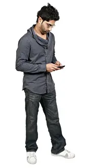 Online Communication Drucke: Young man using a cell phone for texting