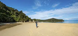 Sandy Ocean Beach Scene Drucke: Young man walking on the beach